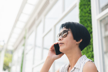 Asian woman sit and talk on cellphone