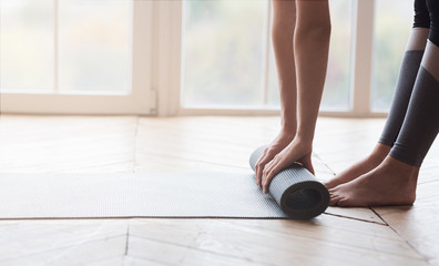Obraz na płótnie Canvas Cropped image of woman rolling sport mat at studio