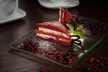 beautifully served red-white cake on a glass plate with a berry