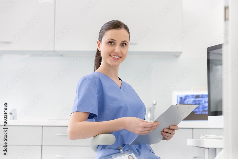 Poster attractive nurse sitting while holding medical record in clinic