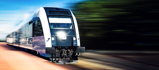 Modern train moving fast on a rail tracks in a blurred motion on with copy space.