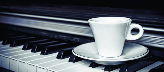 piano keys is a cup of coffee and autumn leaves. Fan lighting. Vintage. Concept - autumn melody, nostalgia mood banner
