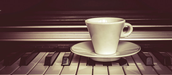 piano keys is a cup of coffee and autumn leaves. Fan lighting. Vintage. Concept - autumn melody, nostalgia mood banner