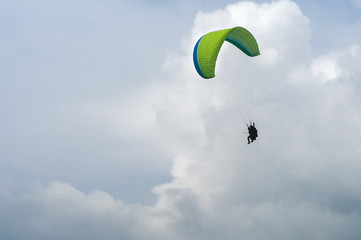 Two people on a paraglider, parachute the wing, fly in the clouds at the peak of the Carpathian mountains and shoot everything on video.