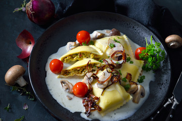 Schwäbische Gemüse-Maultaschen mit Champignonrahmsoße und Röstzwiebeln - Swabian vegetable ravioli with mushroom cream sauce and roasted onion rings, dark and moody style