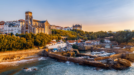 Panoramic view of Biarritz cityscape, coastline with its famous sand beaches and port for small boats. Golden hour. Aquitaine, France. - obrazy, fototapety, plakaty