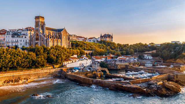 Panoramic view of Biarritz cityscape, coastline with its famous sand beaches and port for small boats. Golden hour. Aquitaine, France.