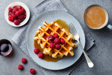 Fresh waffles with cup of coffee and raspberry. Grey background. Top view.