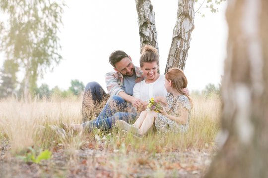 Happy Familly Sitting On Field