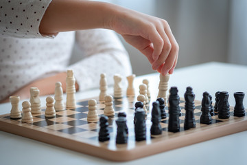 a asia girl learn how to play chess game