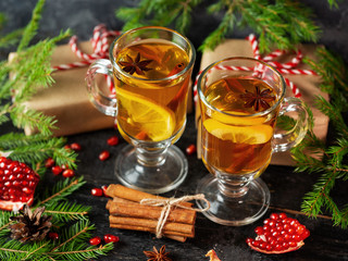 Christmas hot drink mulled wine on a festive table with fir tree branches and gift boxes