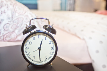 Alarm clock near the bed at home. Morning concept