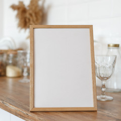 Wooden frame on the kitchen table in the interior.