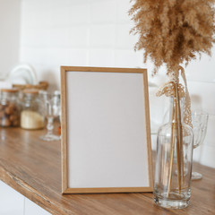 Wooden frame on the kitchen table in the interior.