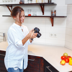 Young attractive girl photographs fruits with a camera