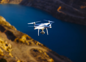 Uav drone copter flying with digital camera above opencast mining quarry.