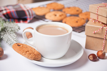 Cup of tea, homemade cookies, Christmas gift boxes and Christmas decor on the white background.