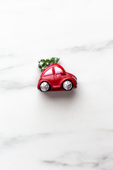 Fototapeta na wymiar New Year Christmas presents red car with Christmas tree on marble background with copy space