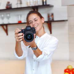 Fototapeta premium Young attractive girl photographs fruits with a camera