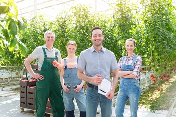 Supervisor standing with farmers in Greenhouse