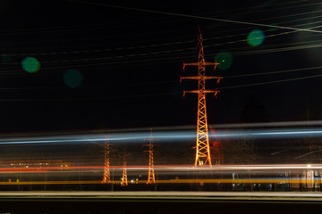 traffic in a night city past power lines