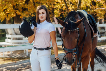 Equestrian sport concept, female jockey and horse in autumn forest.