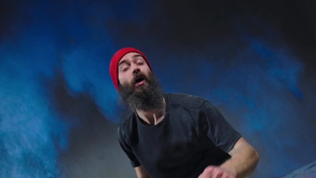 Man dancer showing break-dancing moves against colourful powder explosion