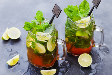 Mojito cocktail in glass jars on grey stone background. Close up.