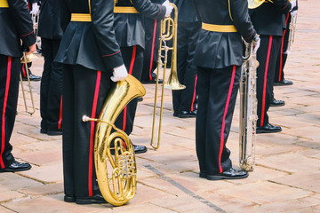 Military musicians on parade with wind instruments in their hands - trombone, tuba, trumpet,...