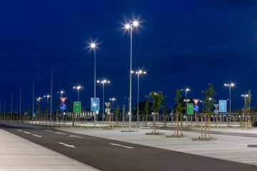 big modern empty parking lot with bright LED street lights at night
