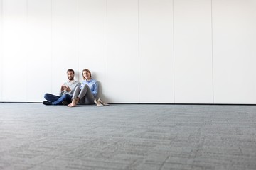 Business people sitting on the floor in office
