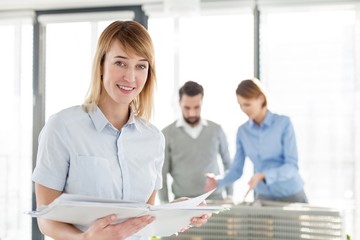 Businesswoman reading document against colleague in meeting