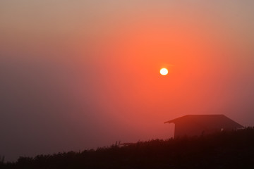 Light and shadow, the view of the small house on the mountain and the sunrise in the morning  Phu Thap Berk, Phetchabun, Thailand.