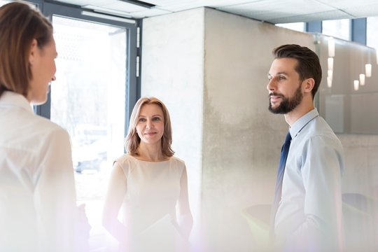 Receptionist Talking To Business Poeple In Office Lobby