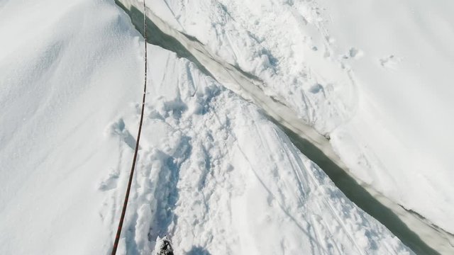 Mountaineer Steps Over Crevasse on the Glacier. FPV View