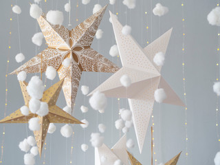 Still life Christmas studio background with a 3d stars and fluffy cotton clouds on a light gray...