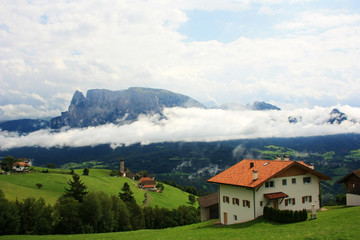 Fototapeta na wymiar Houses on the slopes of the Dolomites