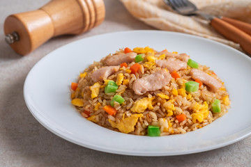 Fried rice chicken with egg and vegetables on white plate.