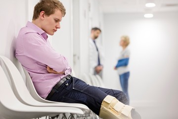 Injured patient sitting while waiting in clinic