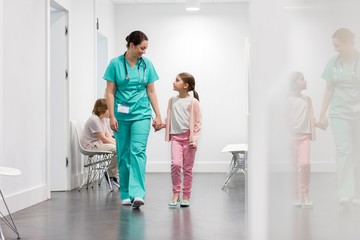 Nurse assisting child patient in clinic