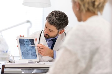 Doctor showing x-ray result to patient in clinic