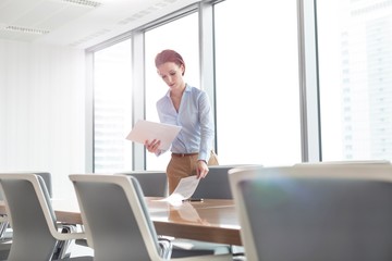 Young secretary preparing papers for meeting in office