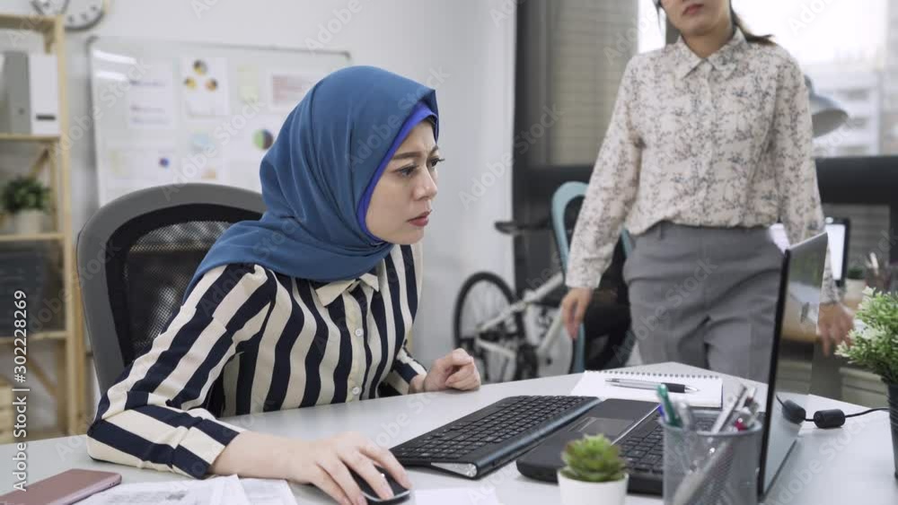 Wall mural Angry muslim female executive firing unprofessional asian chinese woman employee for bad work. diverse business people coworker having conflict at workplace point on laptop computer screen arguing.