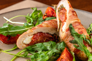 close-up meatloaf with baked tomatoes and green arugula on beige plate at restaurant
