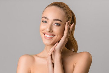 Youth and beauty. Young girl touching her face