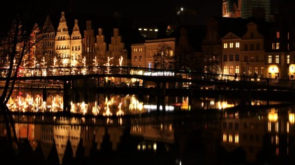 Lübeck at night with view over the Trave river with festive Christmas lighting in winter
