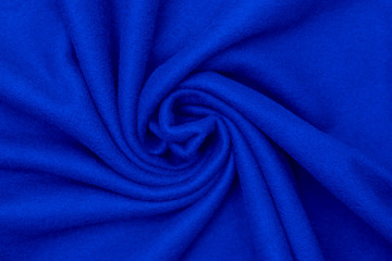  Background soft plush fleece material with relief folds bright blue color.