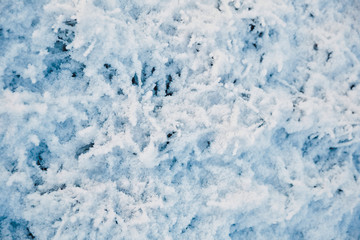 Snow covered frozen grass. White winter texture, top down view.