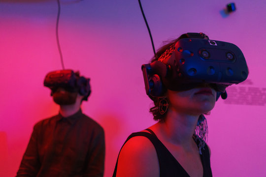 Man and a woman use VR helmet while in virtual reality.