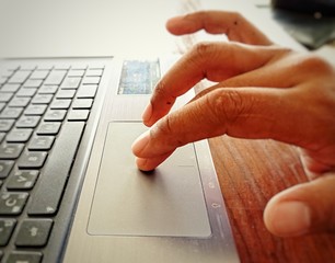 Close up Finger touching the pad on the notebook.